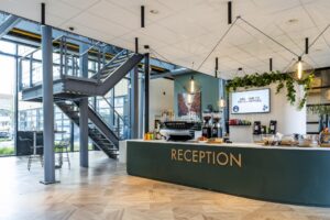 Moderne receptiebalie met koffiecorner in de entree van Stitch Offices aan de H.J.E. Wenckebachweg.